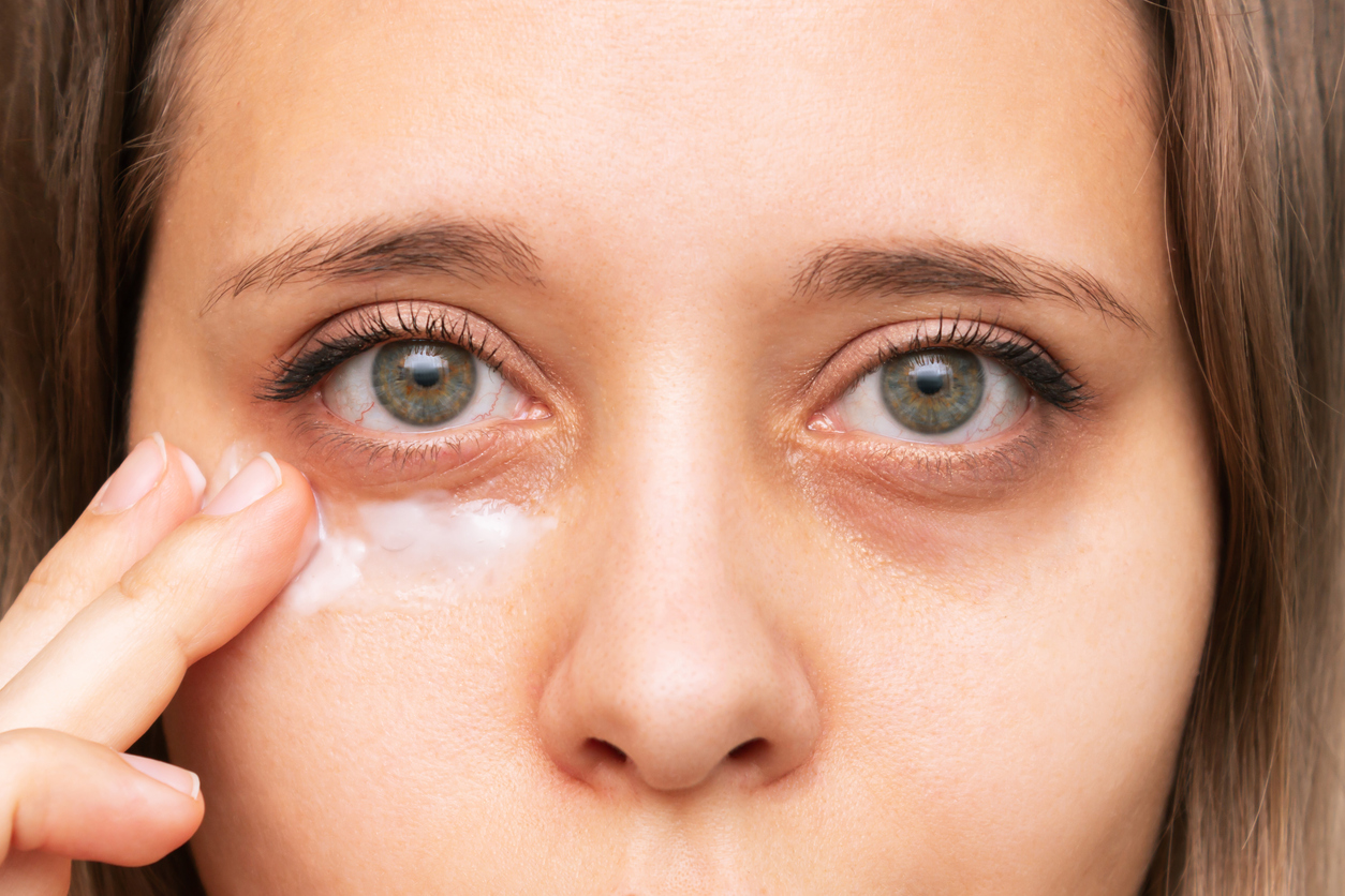A woman using Dr Koo Skincare to get rid of dark circles under her eyes